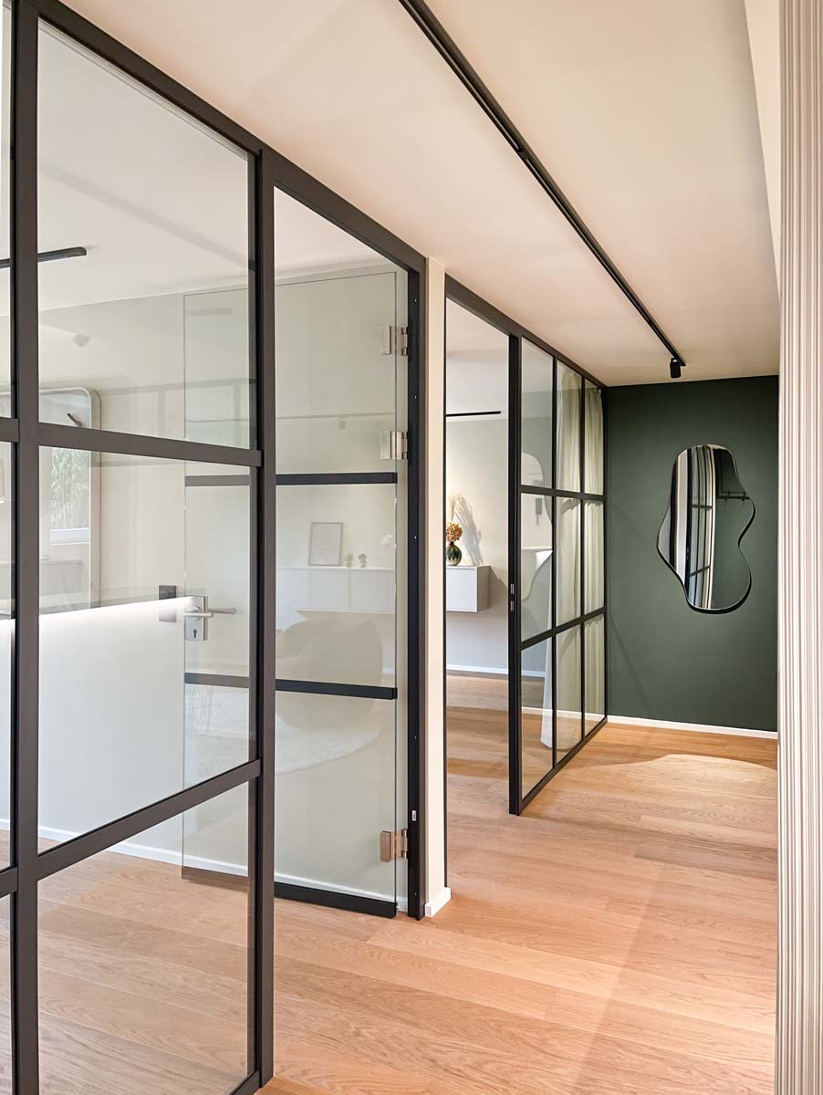 Modern beltéri folyosó egri lakásfelújítás során, fekete fémkeretes üvegfallal és fa padlóval